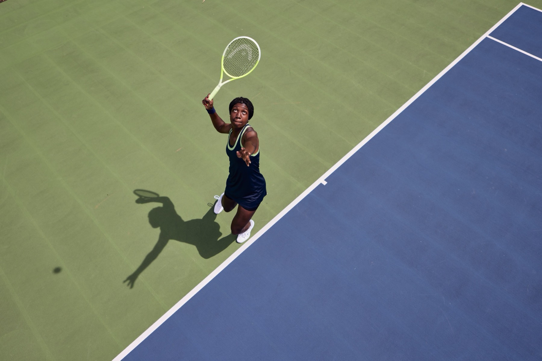 Tennisspielerin beim Aufschlag, von oben fotografiert