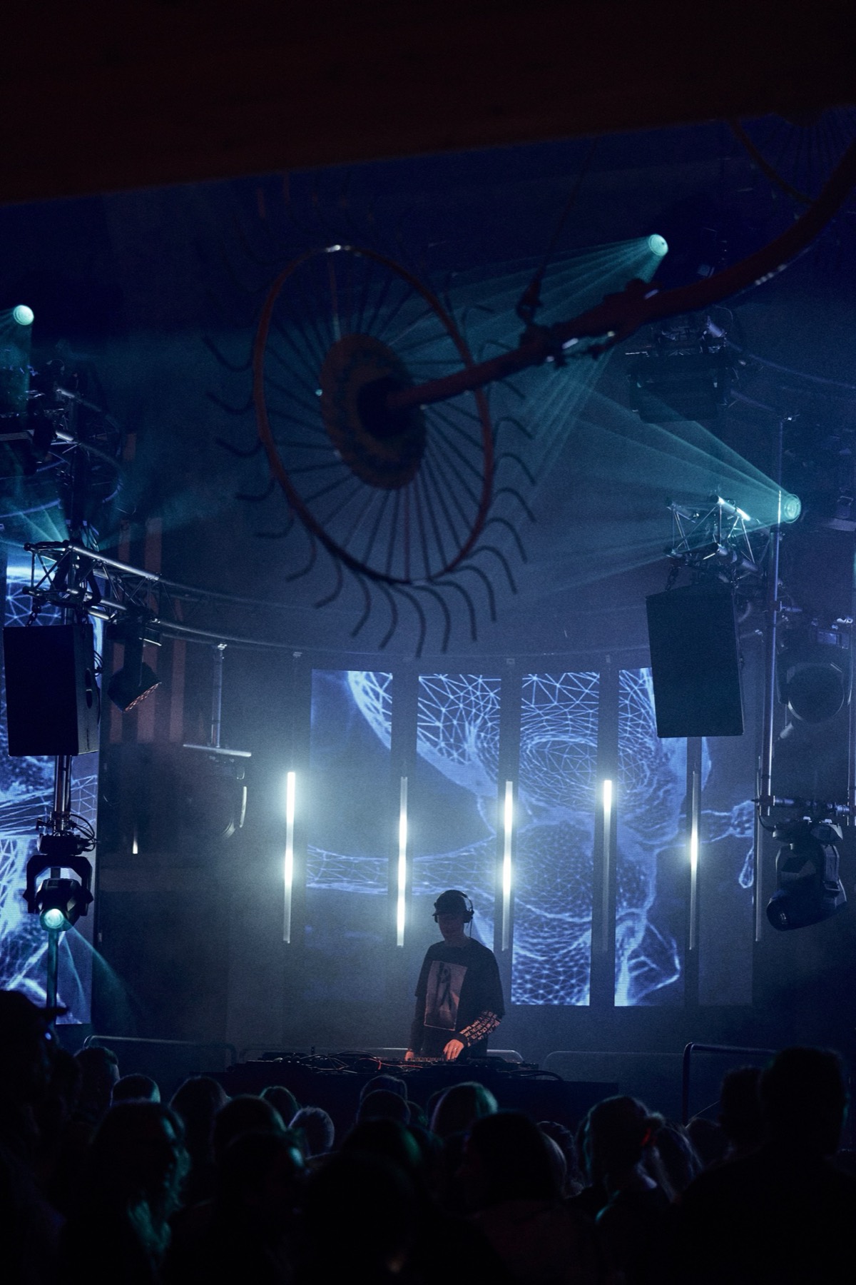 DJ auf der Bühne unter einem großen Wagenrad, Lichtshow